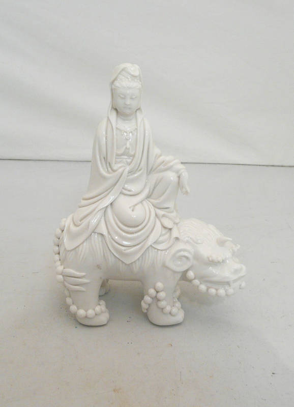 Lot 108 - A Blanc de Chine Figure of Guanyin, Qing Dynasty, the robed figure sitting on the back of a...