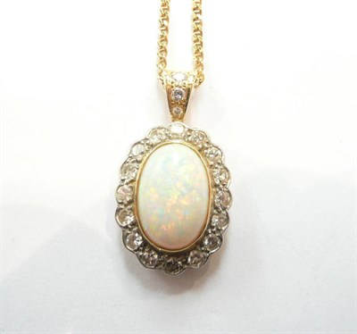 Lot 214 - An opal and diamond cluster pendant on an 18ct gold chain, an oval cabochon opal within a border of