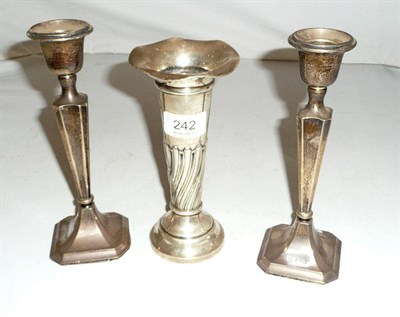 Lot 242 - A pair of silver candlesticks and a trumpet vase (all loaded) (3)