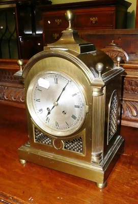 Lot 373 - A two train brass cased mantel clock with circular silvered dial, two winding apertures, a...