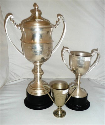 Lot 435 - A large twin handled trophy cup, cover and stand and two smaller others