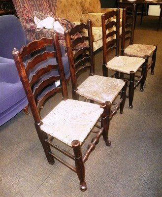 Lot 576 - Set of four oak ladder back rush seated dining chairs