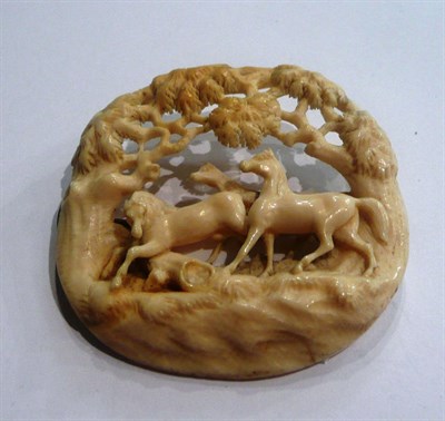 Lot 10 - A carved ivory brooch depicting three horses