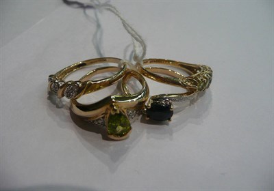 Lot 48 - Four 9ct gold rings set with peridot, diamond and sapphire