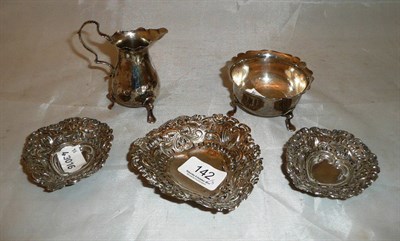 Lot 142 - A small silver cream jug, similar sugar on tripod base and three embossed heart-shaped dishes