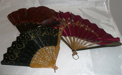 Lot 404 - Late 19th century patent fan with brass sticks and ebonised guards, with a red satin tear drop...