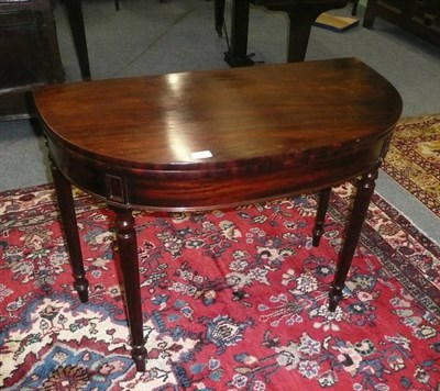 Lot 652 - A mahogany demi lune fold over tea table