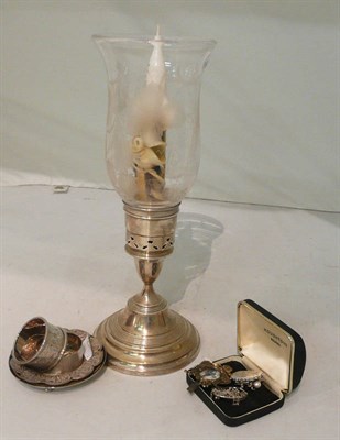 Lot 104 - A silver candleholder, two silver napkins, two brooches, two pairs of earrings, an odd earring,...