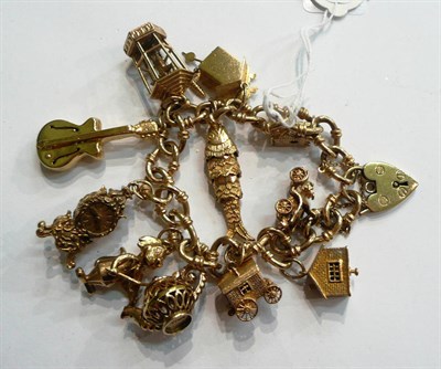 Lot 290 - A charm bracelet hung with eleven charms (one cuckoo clock fir cone detached)