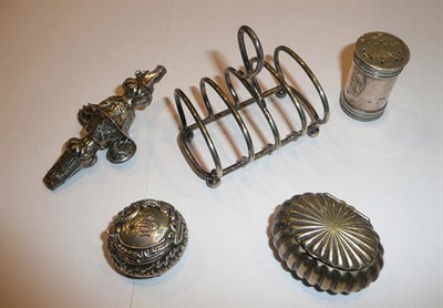 Lot 6 - A child's white metal rattle, a small white metal toast rack, a silver pill box, a silver...