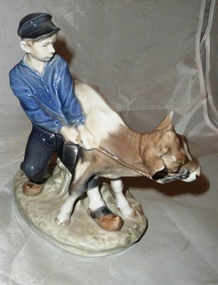 Lot 96 - A Royal Copenhagen ceramic group of a boy and calf