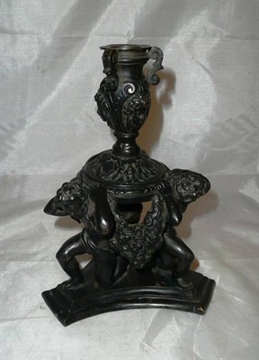 Lot 103 - A bronze candlestick with cherub supports