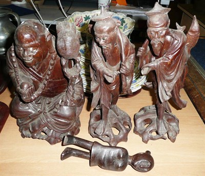 Lot 220 - Three carved hardwood figures and an African figure