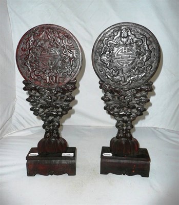 Lot 10 - Pair of carved roundels on pedestal stands