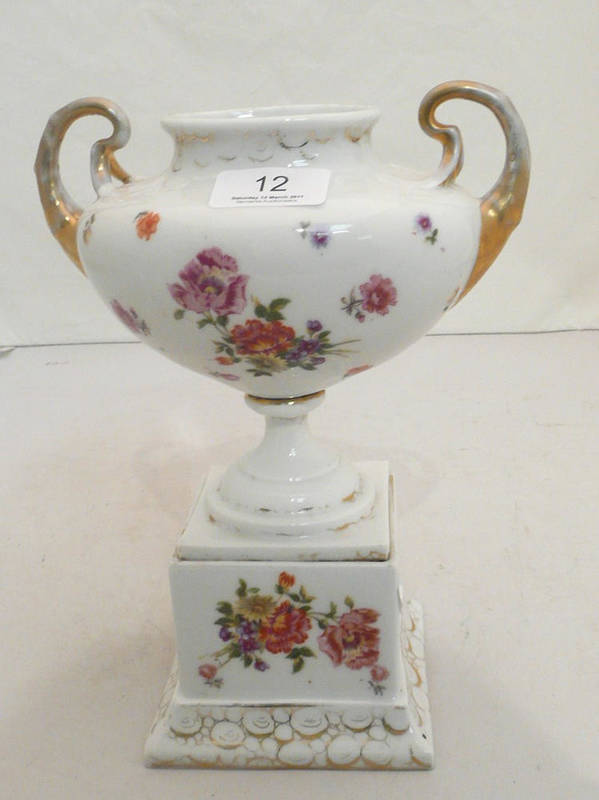 Lot 12 - A porcelain twin handled urn with base