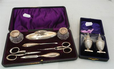 Lot 51 - Cased pair of silver pepperettes and a cased silver manicure set