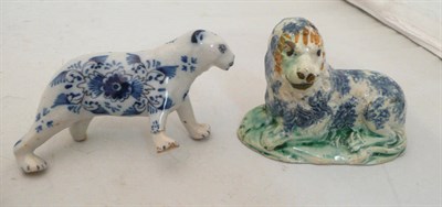 Lot 122 - A 19th century pearlware model of a seated lion and a blue and white decorated dog (2)