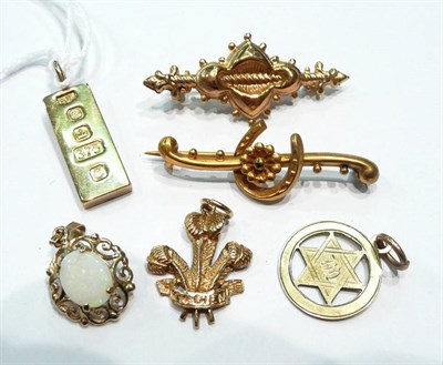Lot 244 - A 9ct gold ingot, two brooches and three pendants