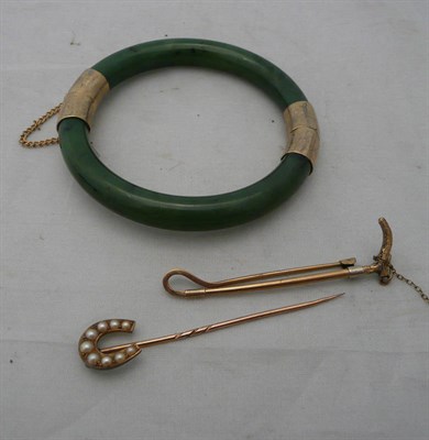 Lot 60 - A 9ct gold hunting stock pin in the form of a hunting crop, another and a jade type bangle