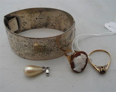 Lot 61 - A cameo ring, a garnet ring, a wide bangle and a pendant