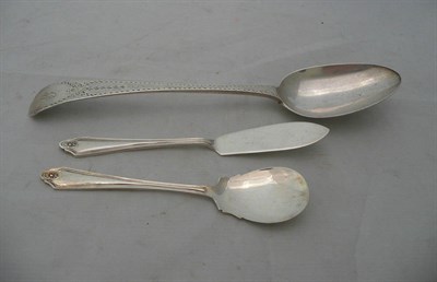 Lot 78 - A Georgian silver spoon with bright cut decoration, a butter spoon and a preserve spoon, 3oz