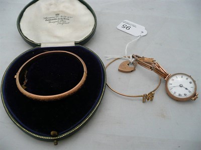 Lot 95 - A 9ct gold bangle, a 9ct padlock, 9ct watch and a yellow metal bangle