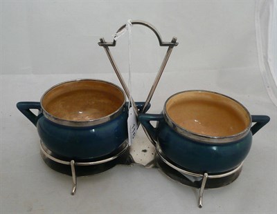 Lot 116 - A pair of Linthorpe two handled blue pottery cauldron shape preserve pots on a plated stand