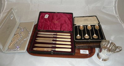 Lot 152 - A silver Christening mug, two sets of teaspoons, a set of cased fruit knives, a costume...