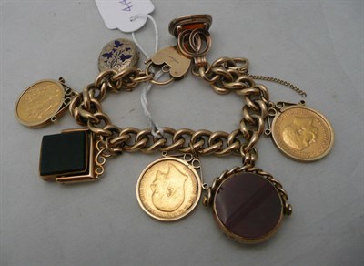 Lot 217 - 9ct gold charm bracelet with three seals, a locket and three loose-set full sovereigns