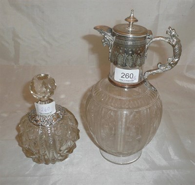 Lot 260 - A cut glass claret jug with plated mounts and a cut glass scent bottle with silver mounts