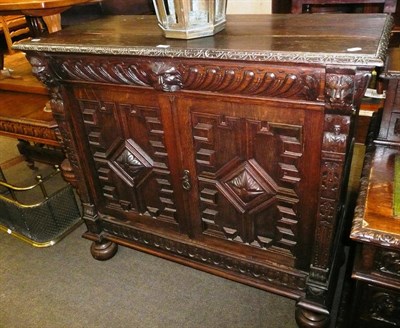 Lot 434 - Carved oak cupboard with key