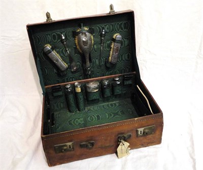 Lot 1095 - Leather Vanity Case with a green silk lining including hammered silver mounted fittings...