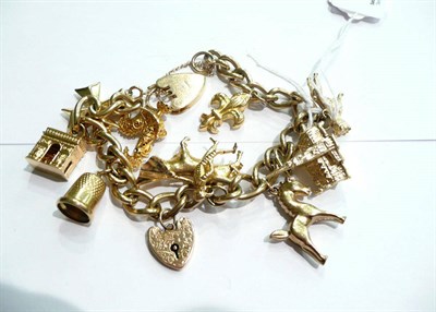 Lot 74 - A 9ct gold curb and lock bracelet hung with ten charms and with a loose maple leaf charm