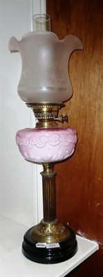 Lot 117 - A Victorian brass oil lamp with wooden reeded column and opaque pink glass reservoir