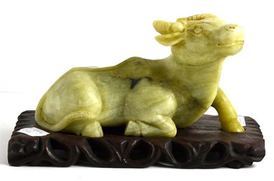 Lot 123 - A Chinese Carved Jade Model of a Recumbent Buffalo, 20cm long, on a hardwood stand