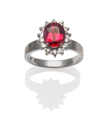 Lot 258 - A Synthetic Ruby and Diamond Cluster Ring, an oval mixed cut ruby within a border of single-cut...