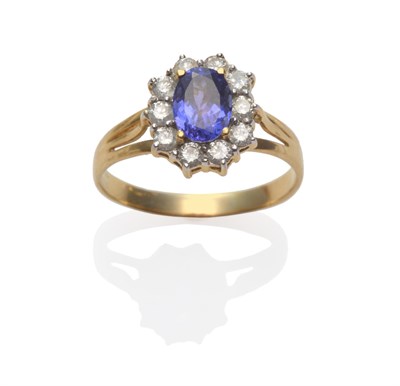 Lot 274 - A Tanzanite and Diamond Cluster Ring, the oval cut tanzanite within a border of round brilliant cut