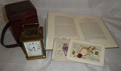 Lot 11 - A brass carriage timepiece, seven embroidered silk postcards and a reprint book