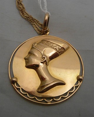 Lot 75 - A disc pendant of Neffertiti, stamped 750 on chain