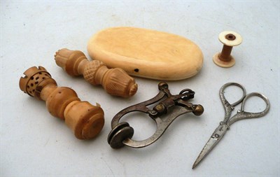 Lot 81 - Two vegetable ivory needle cases, a skirt lifter, bobbin, embroidery scissors and a sewing case etc
