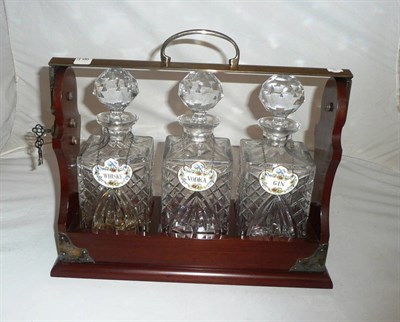Lot 148 - A mahogany three bottle tantalus with plated mounts