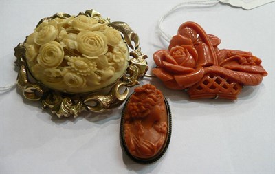 Lot 104 - A coral basket brooch (a.f.), a coral cameo brooch and an ivory floral brooch