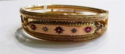 Lot 106 - A cased bangle set with red stones