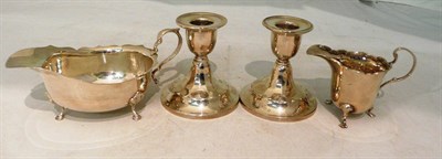 Lot 213 - Silver sauce boat, silver cream jug and a pair of silver loaded squat candlesticks