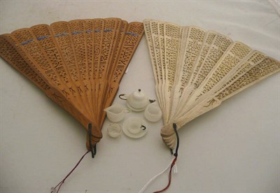 Lot 233 - Pierced bone fan, treen fan and dolls miniature white opaque tete-a-tete set