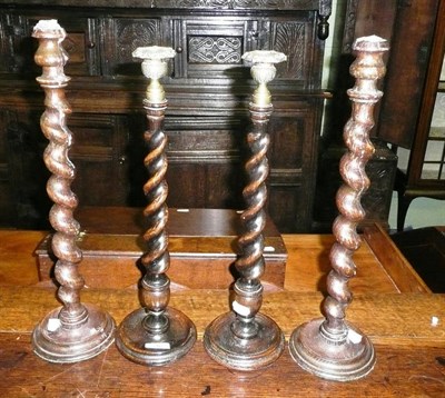 Lot 346 - A pair of oak barley twist candlesticks with brass drip pans and a similar pair (4)