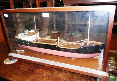 Lot 567 - A wooden model of a coastal steamer, with red and black painted hull and twin masts in a glazed...