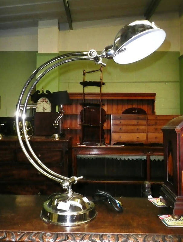 Lot 571 - A white metal desk lamp on a circular base