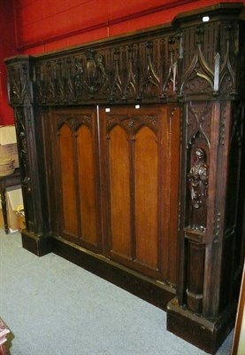 Lot 898 - A carved oak cupboard, carved with figures and crest