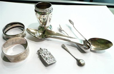 Lot 64 - A small quantity of silver including two napkin rings, sugar tongs, silver brooch 'LMCPE', and...